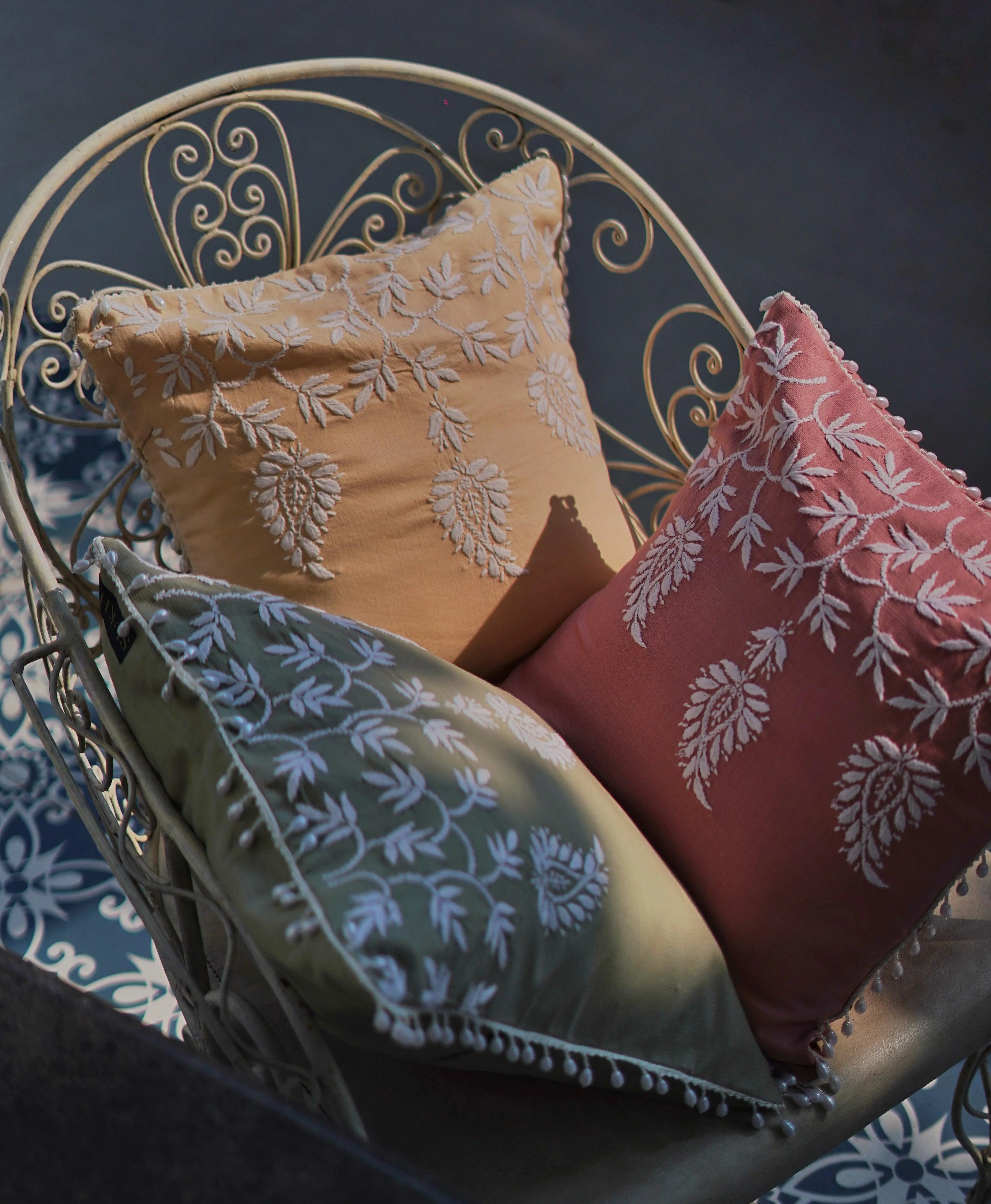 Handmade home furnishings by Sukhara, including premium Chikankari cushion covers featuring eco-friendly designs inspired by mango trees and fields.