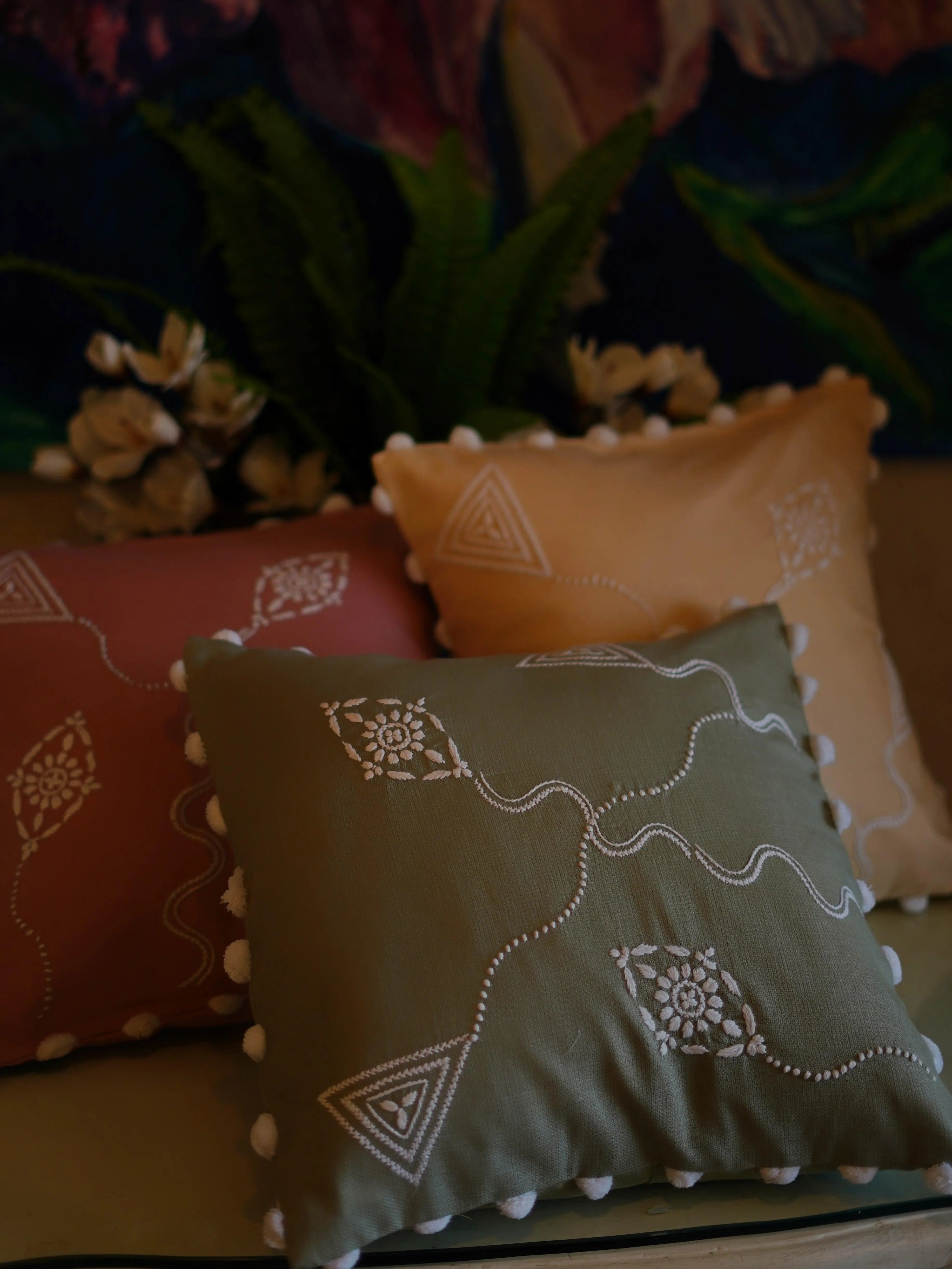Chikankari cushion cover nestled among soft throws, creating a cozy and inviting space filled with the charm of traditional Lucknow craftsmanship.