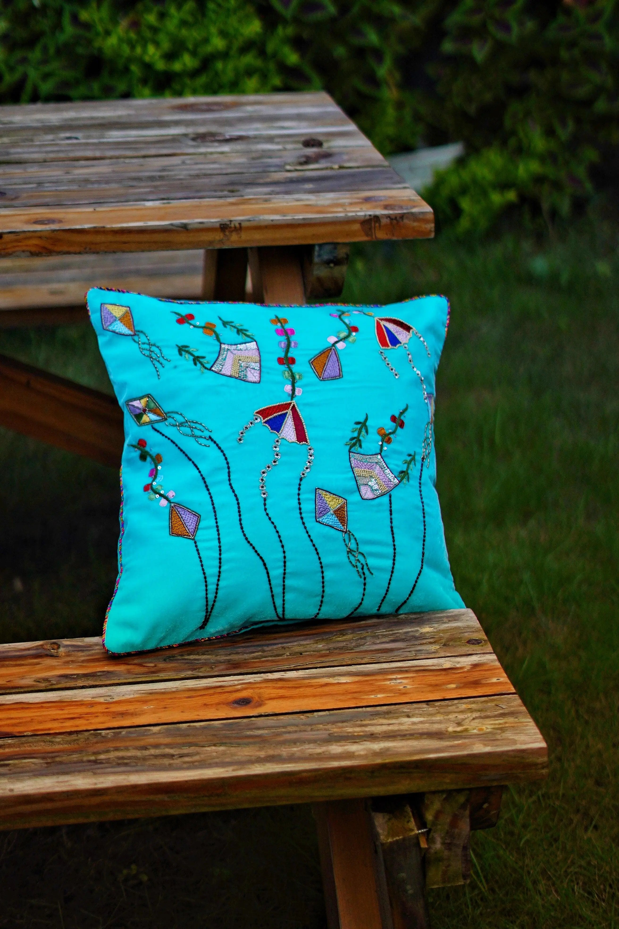 tylish sky blue Zardozi cushion cover elegantly placed on a sofa, adding a touch of luxury and sophistication to modern living room decor